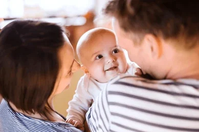 Happy parents with their infants, feeling confident after reading our newborn care guide.