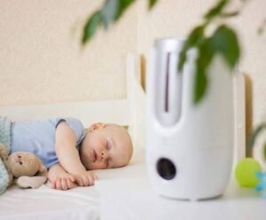  A baby is sound asleep, holding a toy tightly. In the background, a modern baby humidifier gently emits a fine mist into the room.